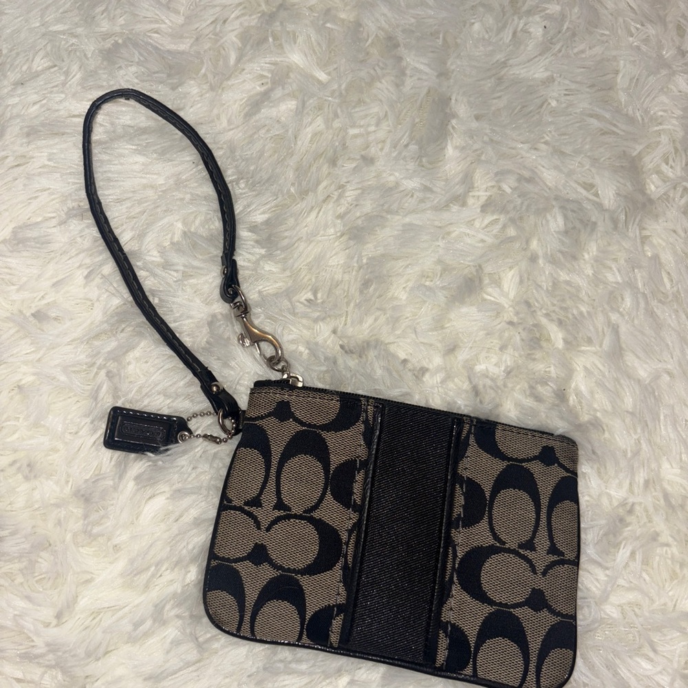 Coach wristlet with the classic “C” logo pattern
